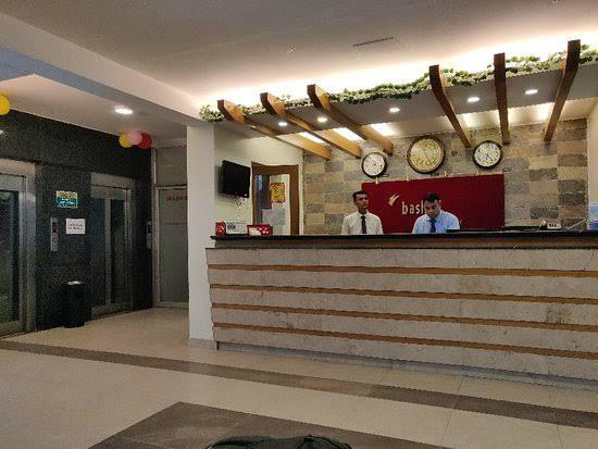 Reception Area with Staff at Check-In Desk Hotel reception area with two staff members behind the counter.