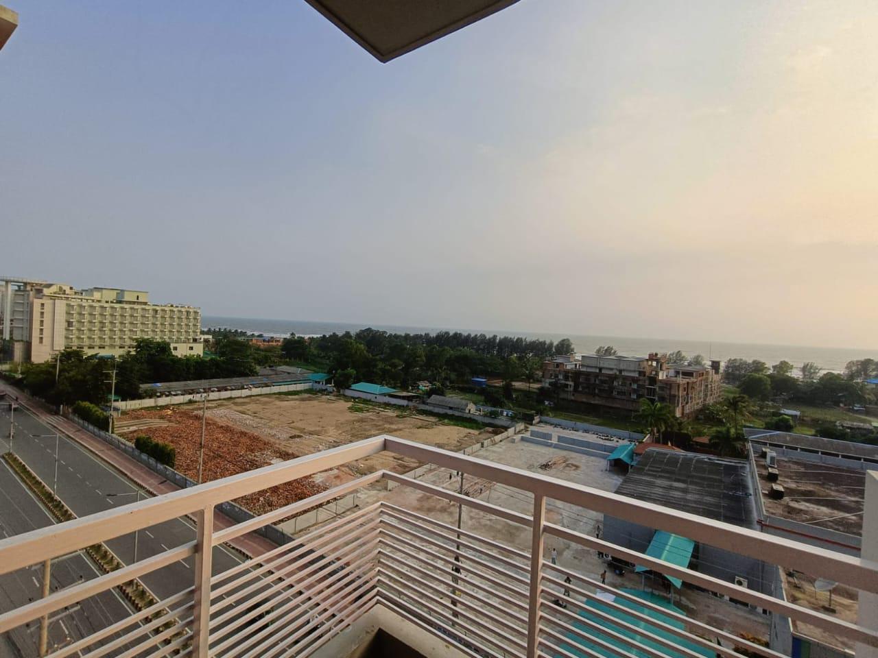Balcony View of Sea and Cityscape Balcony view of the ocean and surrounding buildings during sunset.
